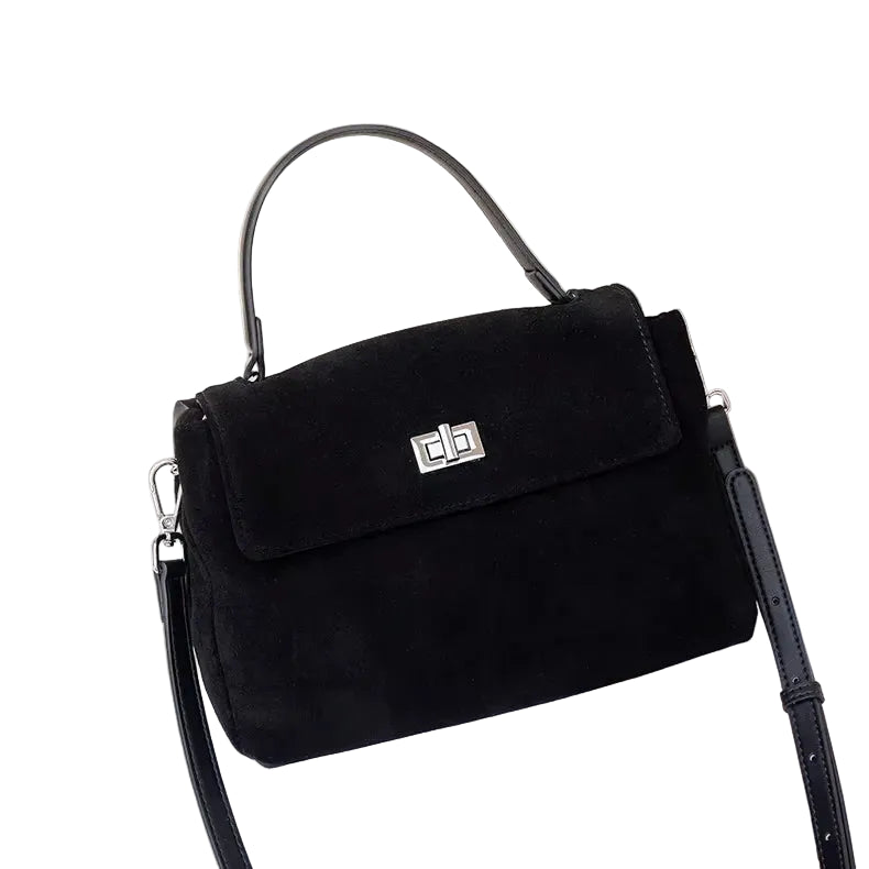 Black handbag with a silver clasp on a white surface