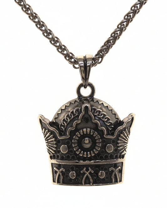 Crown-shaped pendant on a chain against a white background
