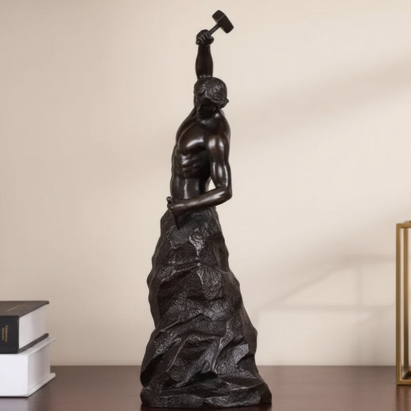 Bronze statue of a figure lifting a dumbbell on a gray background
