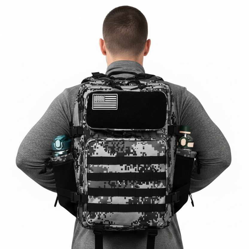 Person wearing a digital camouflage backpack with American flag patch on a white background