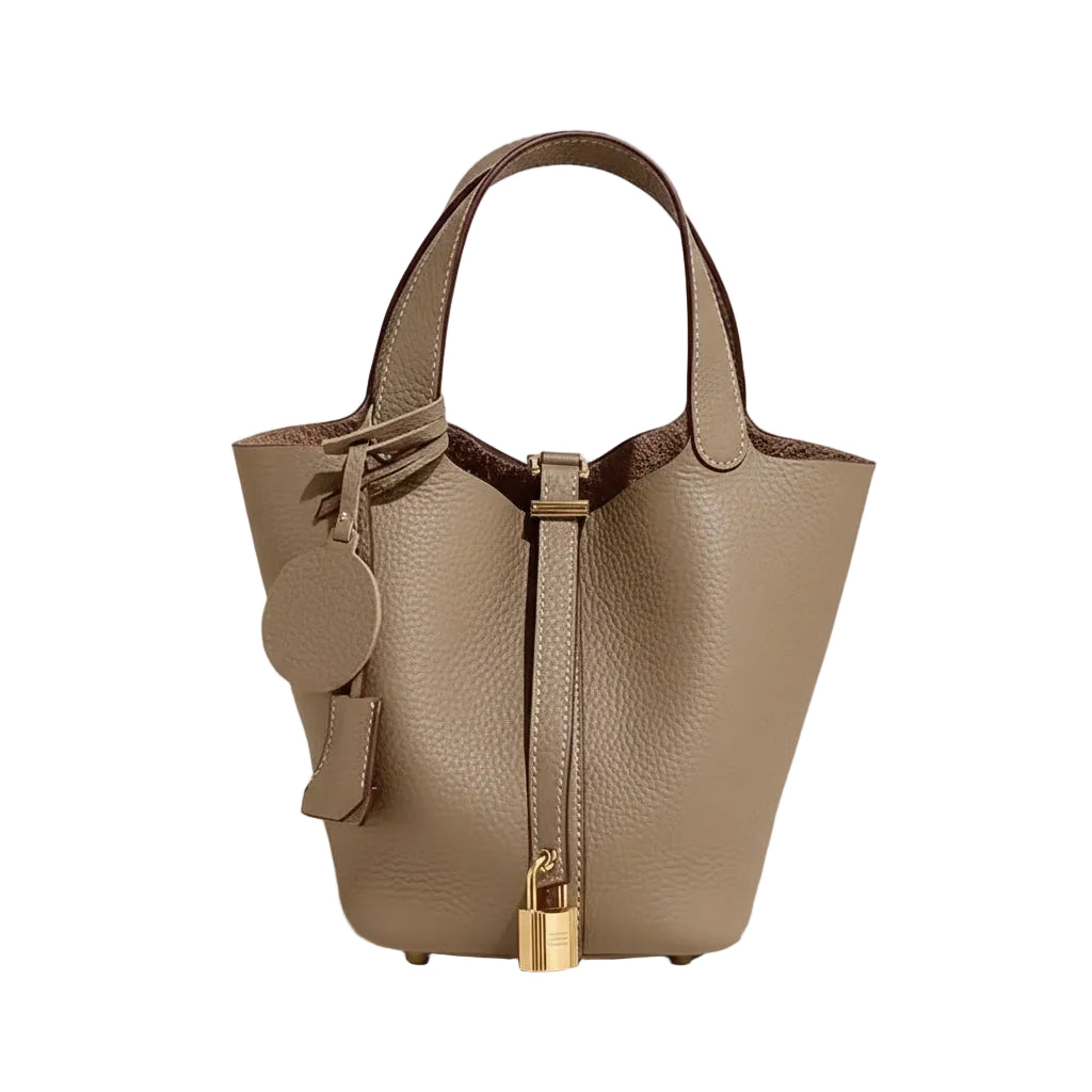 Beige handbag with gold accents on a light gray background