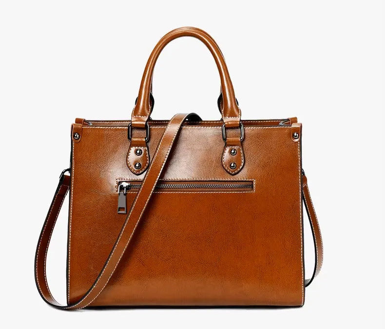 Brown leather handbag with a shoulder strap on a white background