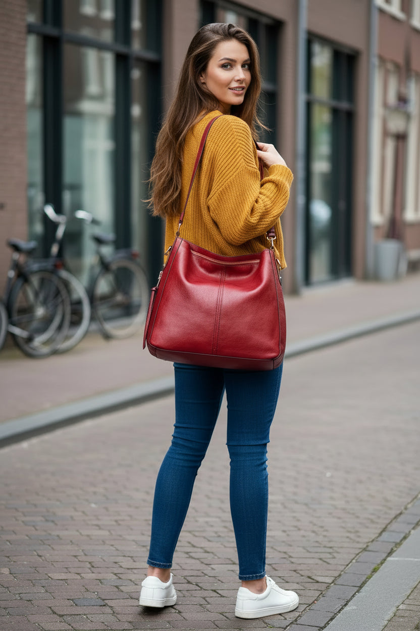 Red handbag with a shoulder strap on a white background