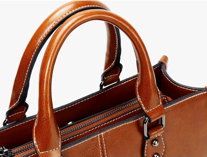 Brown leather handbag with handles on a white background