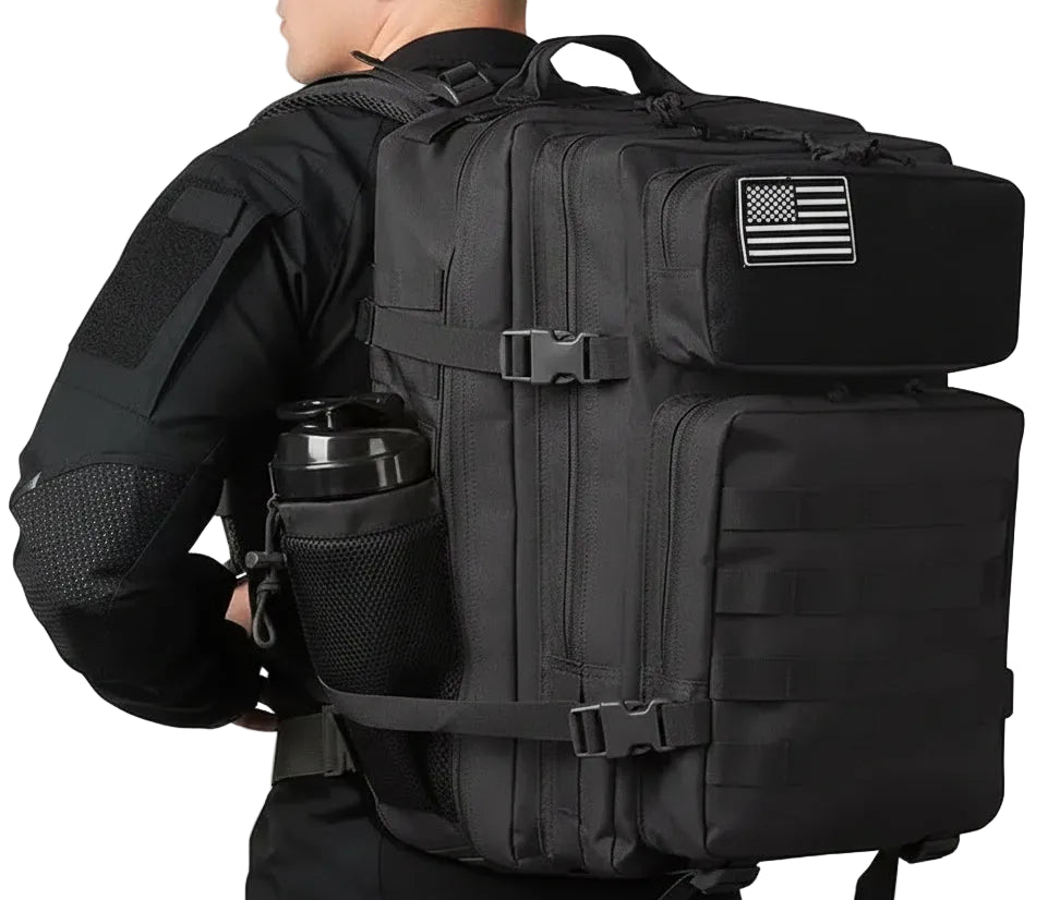 Person wearing a black tactical backpack with an American flag patch on a white background