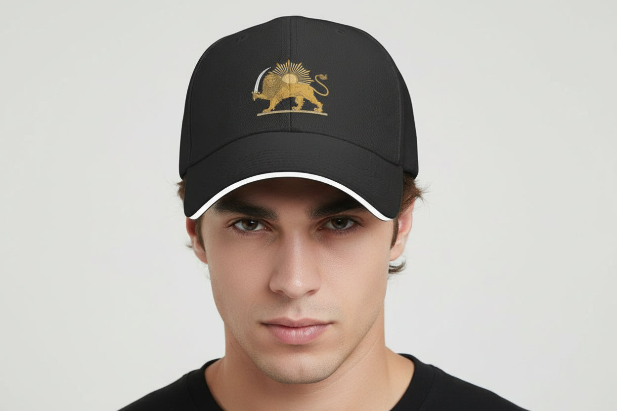 Man wearing a black cap with a gold emblem on a light gray background