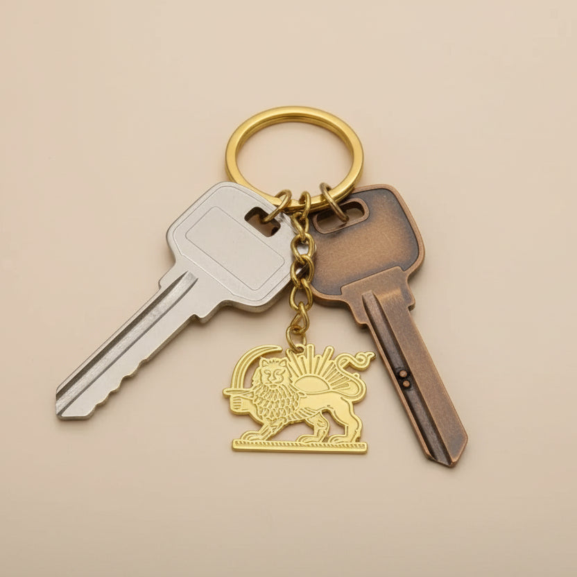 Gold keychain with lion emblem and measurement label on a white background